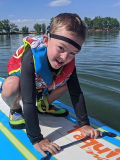 A little boy on a paddle board